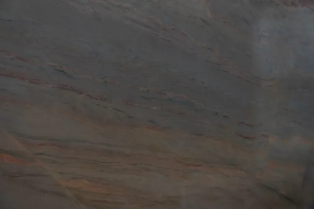 Close-up of layered gray and brown stone with subtle red and blue streaks