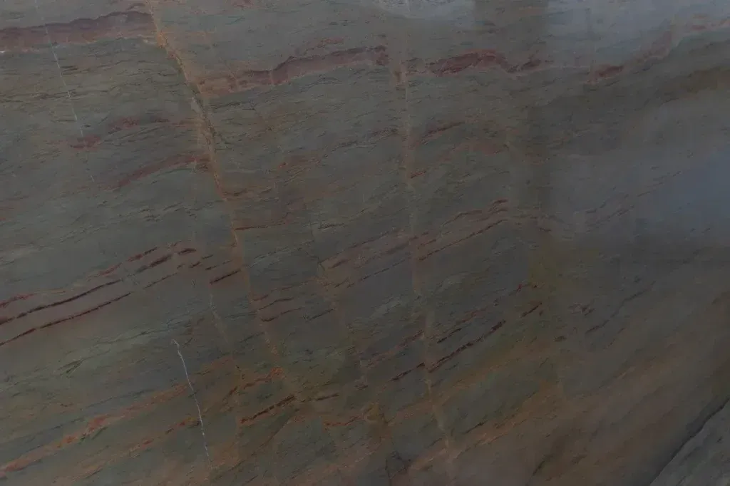 Close-up of a weathered stone surface with gray, tan, and reddish streaks