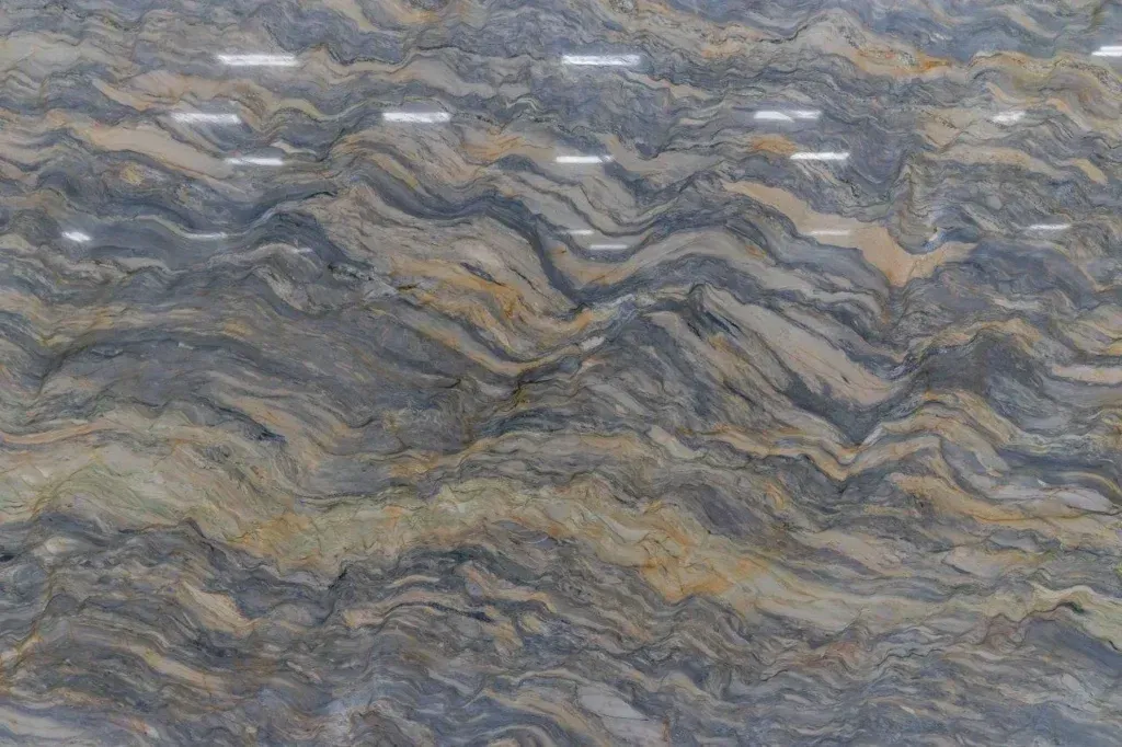 Close-up of layered gray, tan, and blue wavy rock patterns