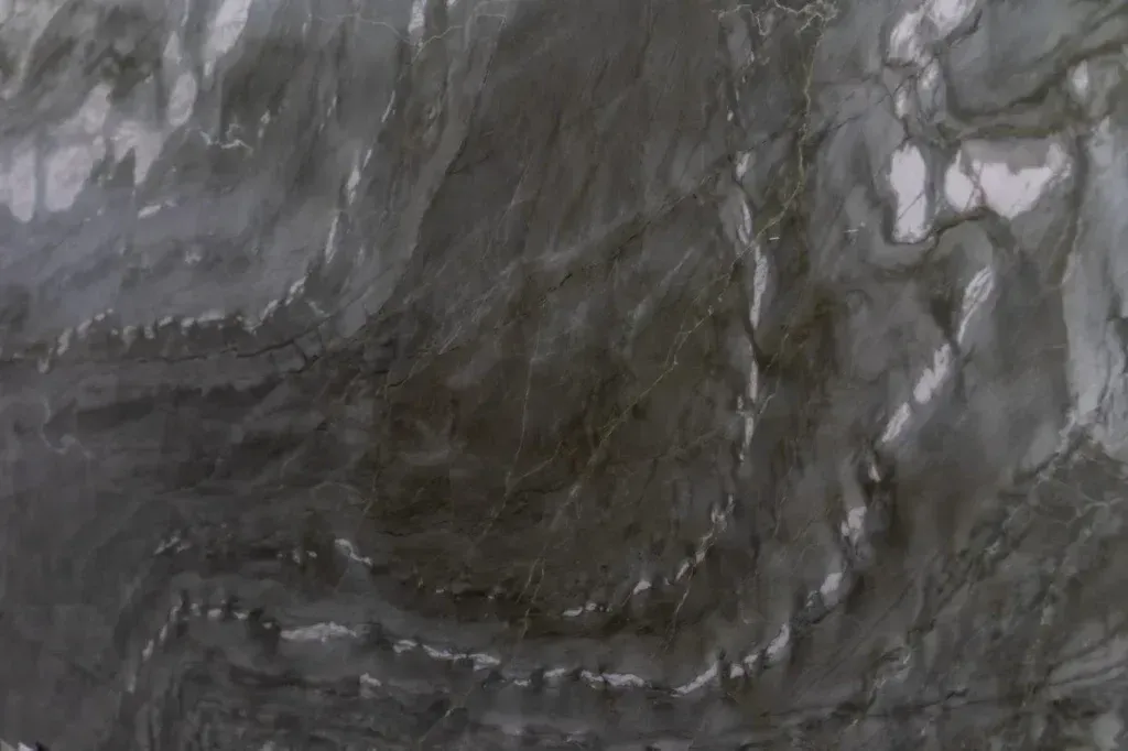 Dark gray and white marbled stone texture with flowing veins