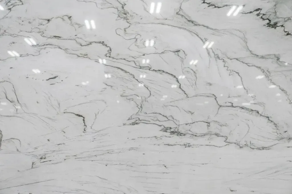 White marble surface with subtle gray veining and glossy reflections