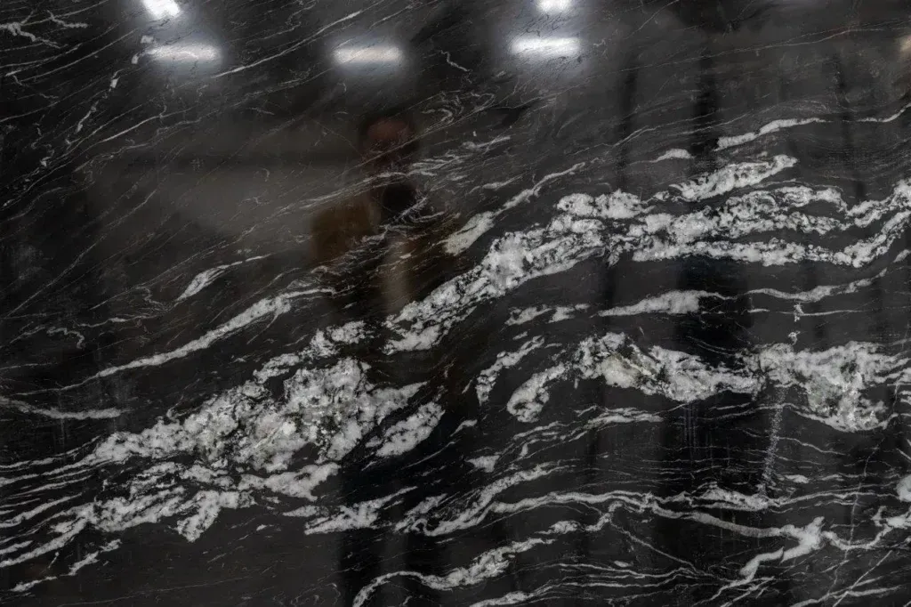 Abstract black-and-white textured surface with wavy white streaks and reflections