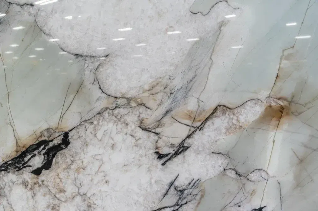 White marble surface with gray veining and dark and tan mineral streaks