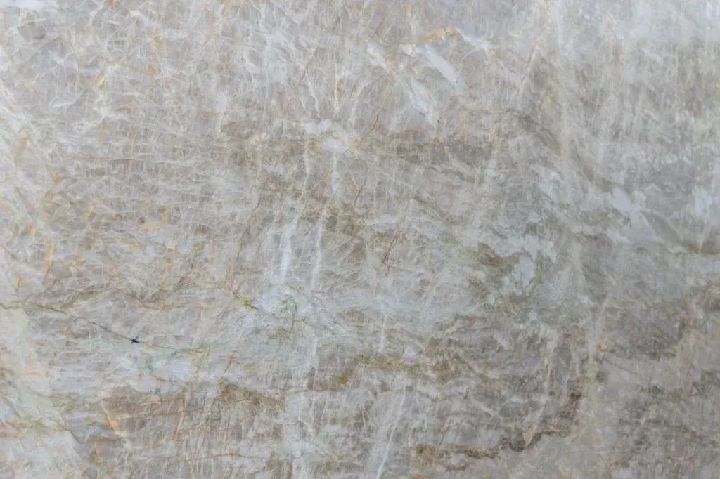 Close-up of a light gray and beige textured stone or fabric surface