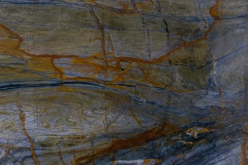 Close-up of a textured rock surface with gray, brown, and blue striations