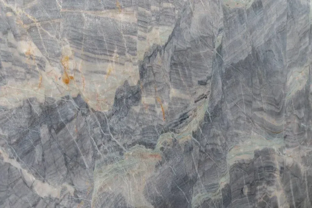 Gray and beige marble-like stone surface with natural veining and cracks