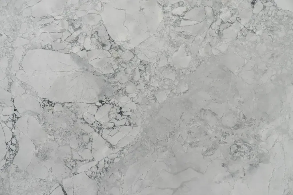 Light gray marble-like textured surface with subtle white and dark veining