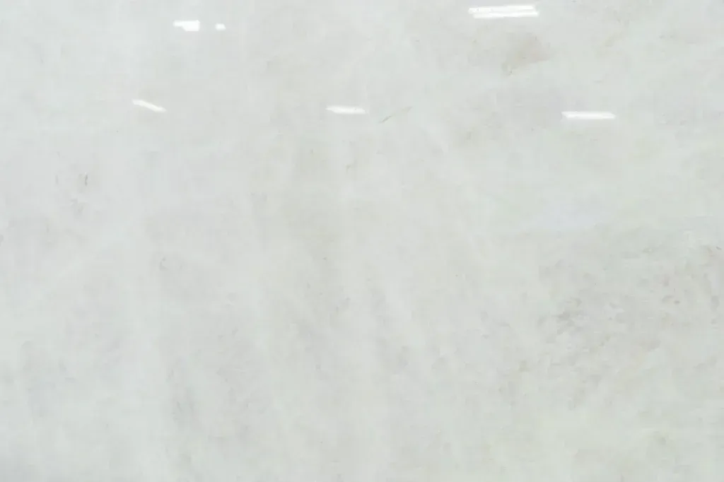Blank white textured surface with faint gray markings and small light reflections