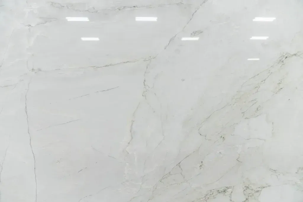 White marble surface with subtle gray veining and bright overhead reflections