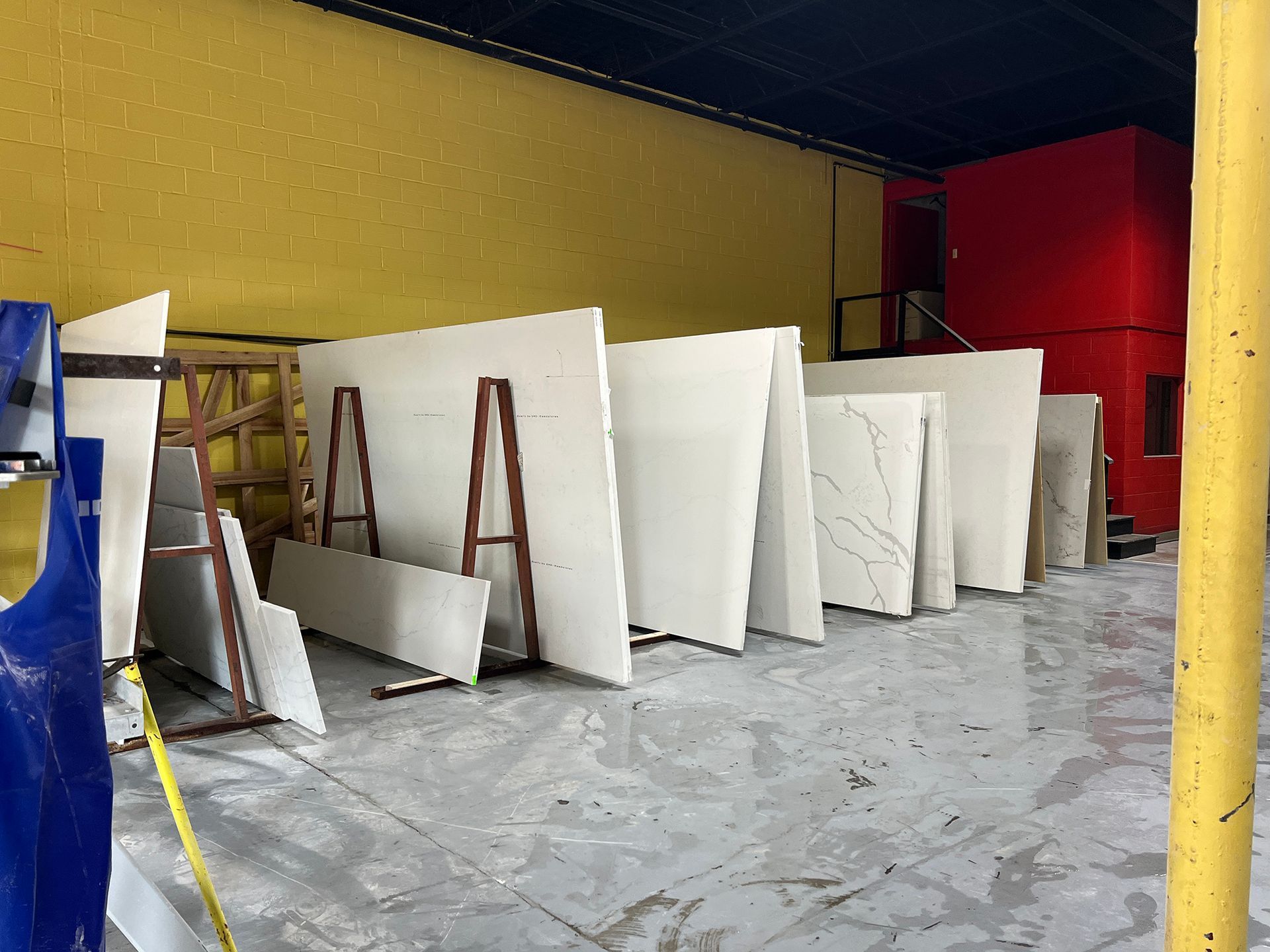 Rows of white panels on stands in a yellow and red workshop interior