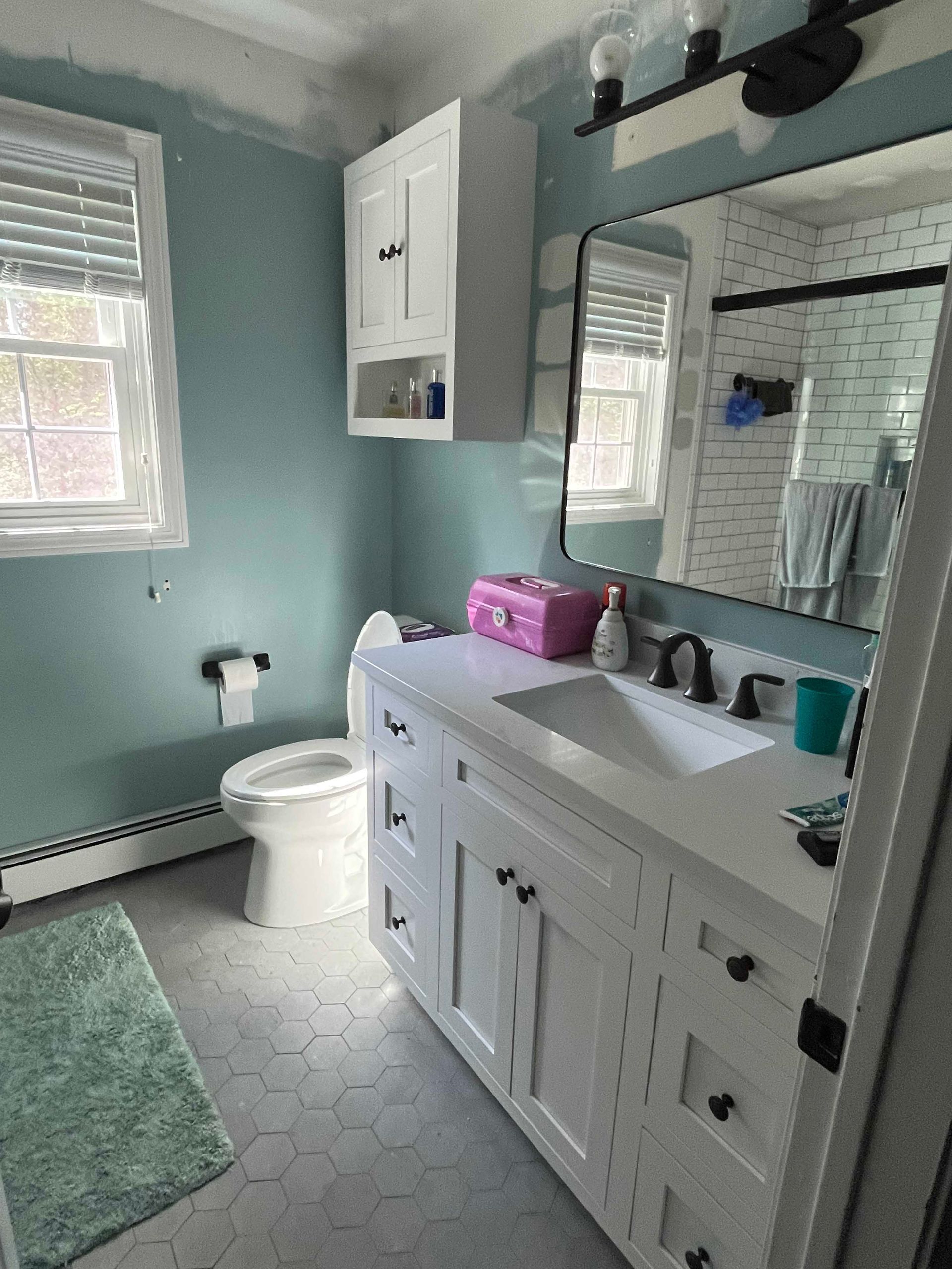 A bathroom with a toilet , sink , and mirror