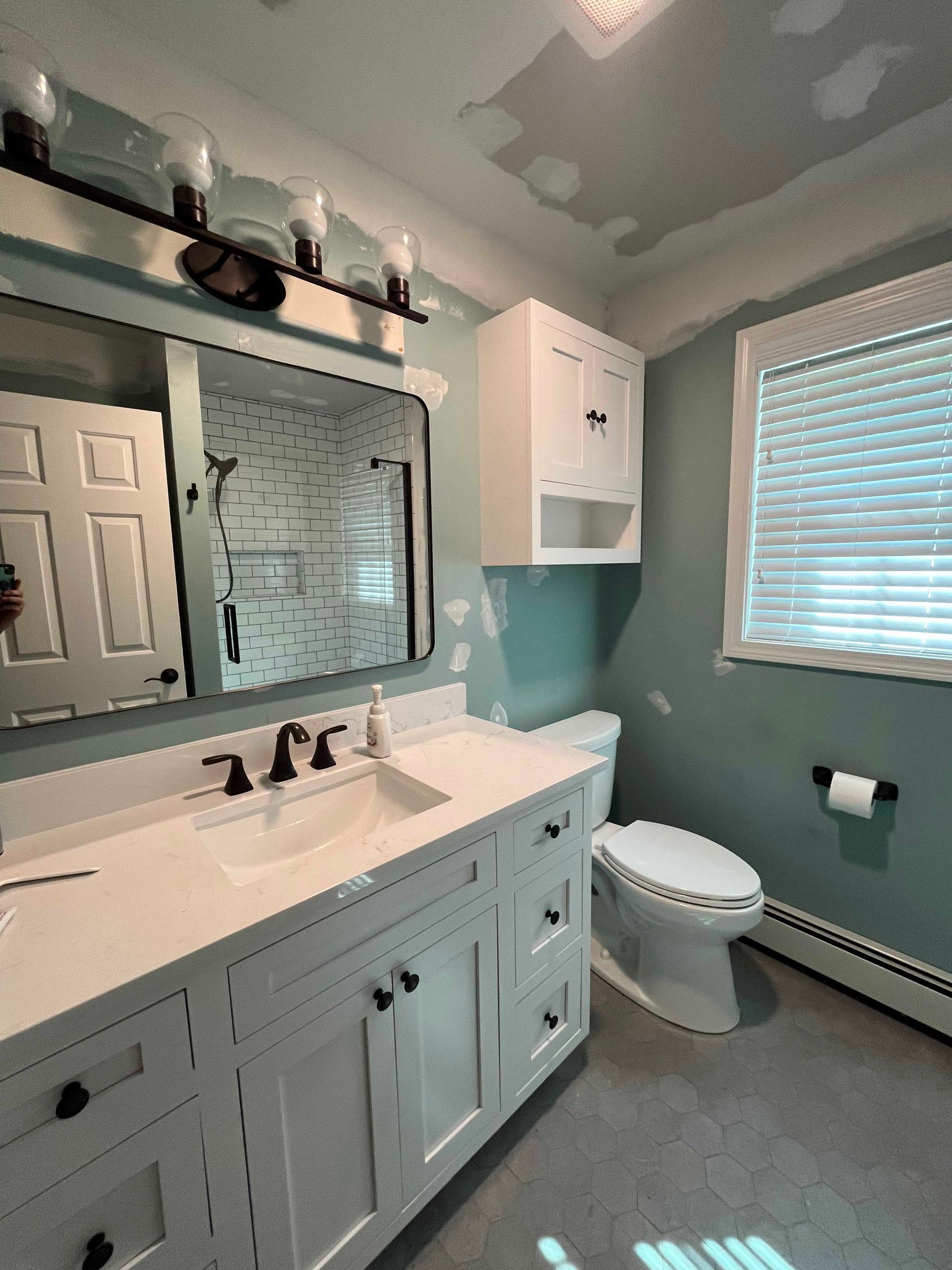 A bathroom with a sink , toilet and mirror