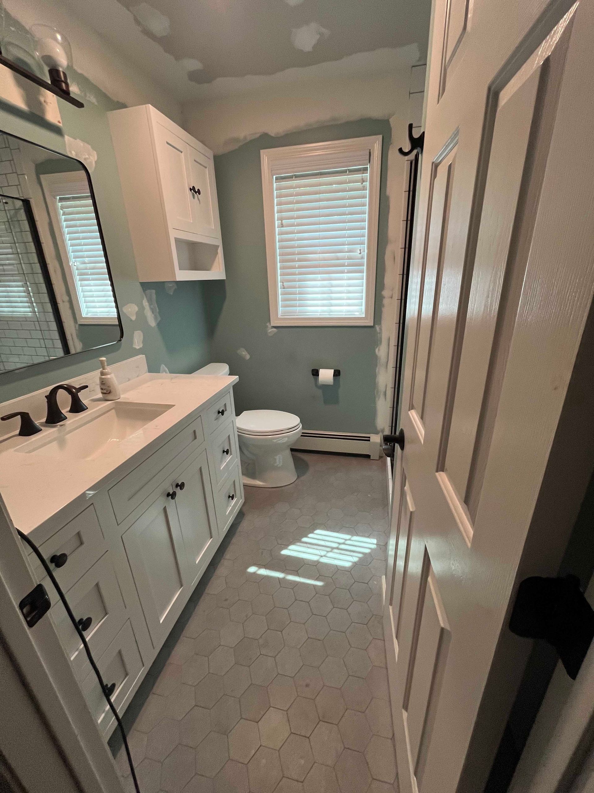 A bathroom with a sink , toilet and mirror.