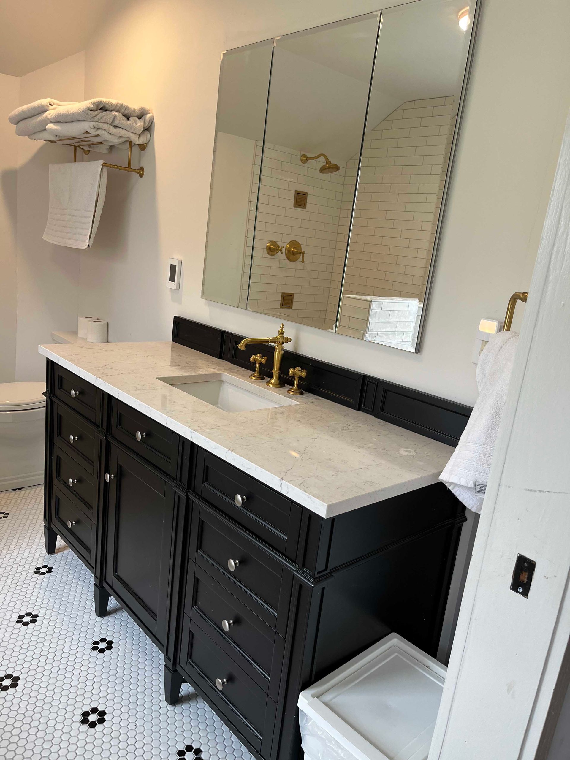 A bathroom with a sink , mirror and toilet.