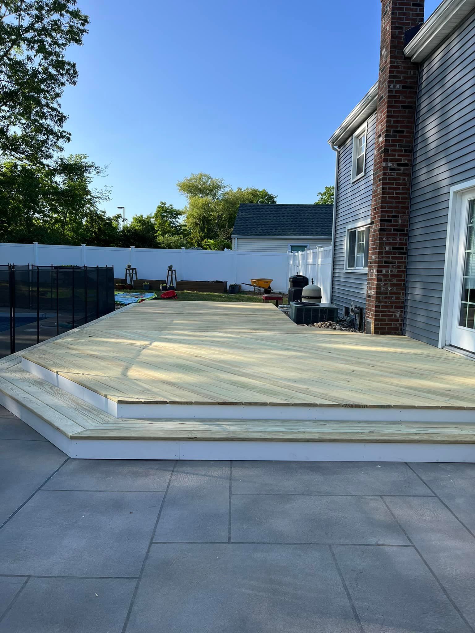 A wooden deck is being built in front of a house.