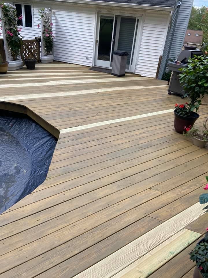 A wooden deck with a swimming pool in the background.