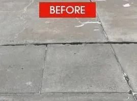 Cracked concrete sidewalk with a red 