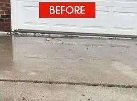 Before view of wet concrete driveway in front of a white garage door.