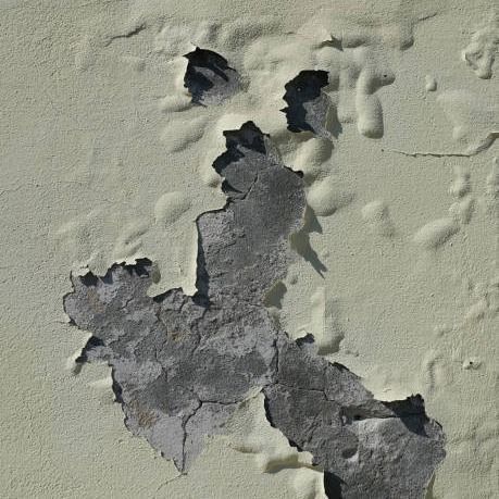 Cracked, peeling yellow paint exposing gray concrete beneath on an exterior wall.