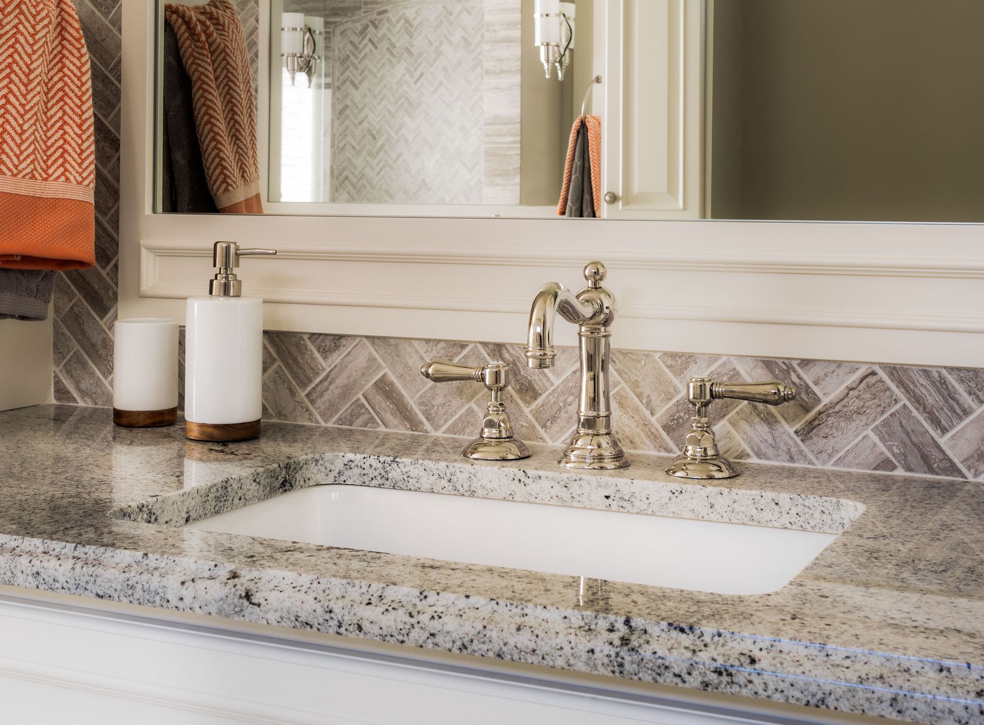 A bathroom sink with a soap dispenser and a mirror.