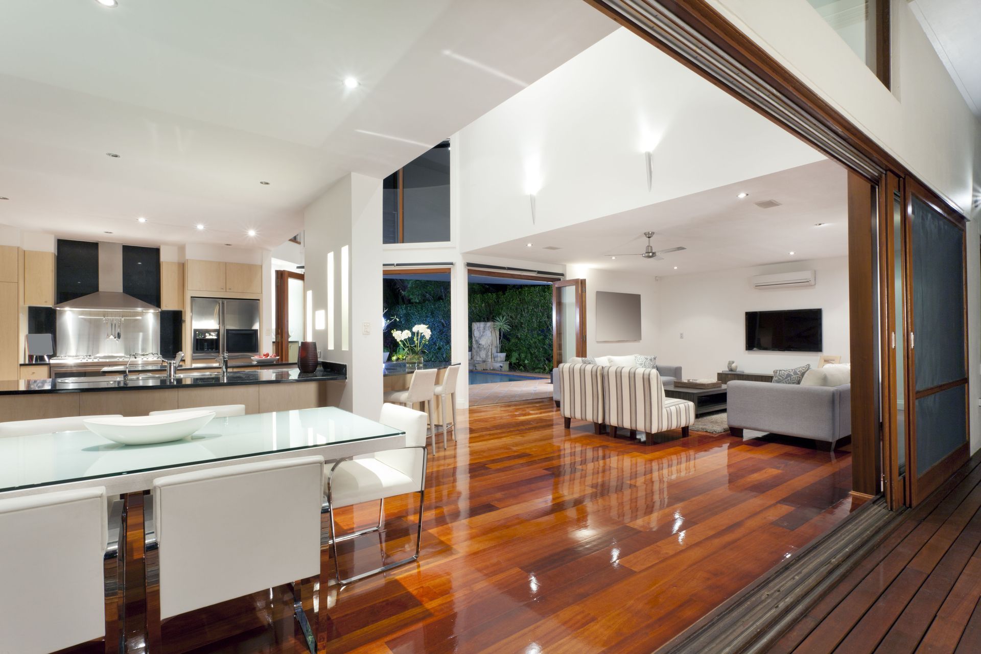 A living room with hardwood floors and a dining table and chairs