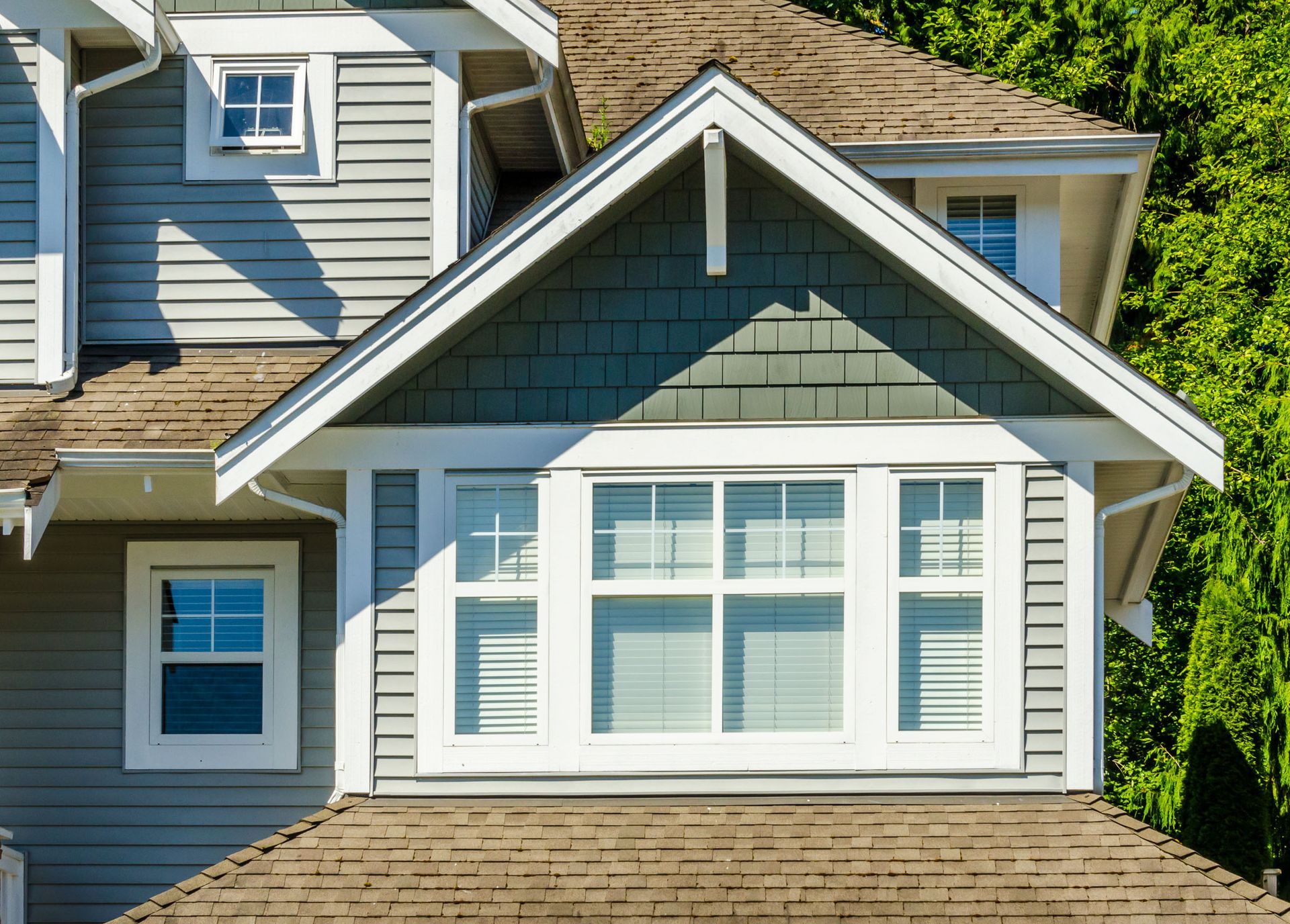 The roof of a house with a lot of windows and trees in the background.