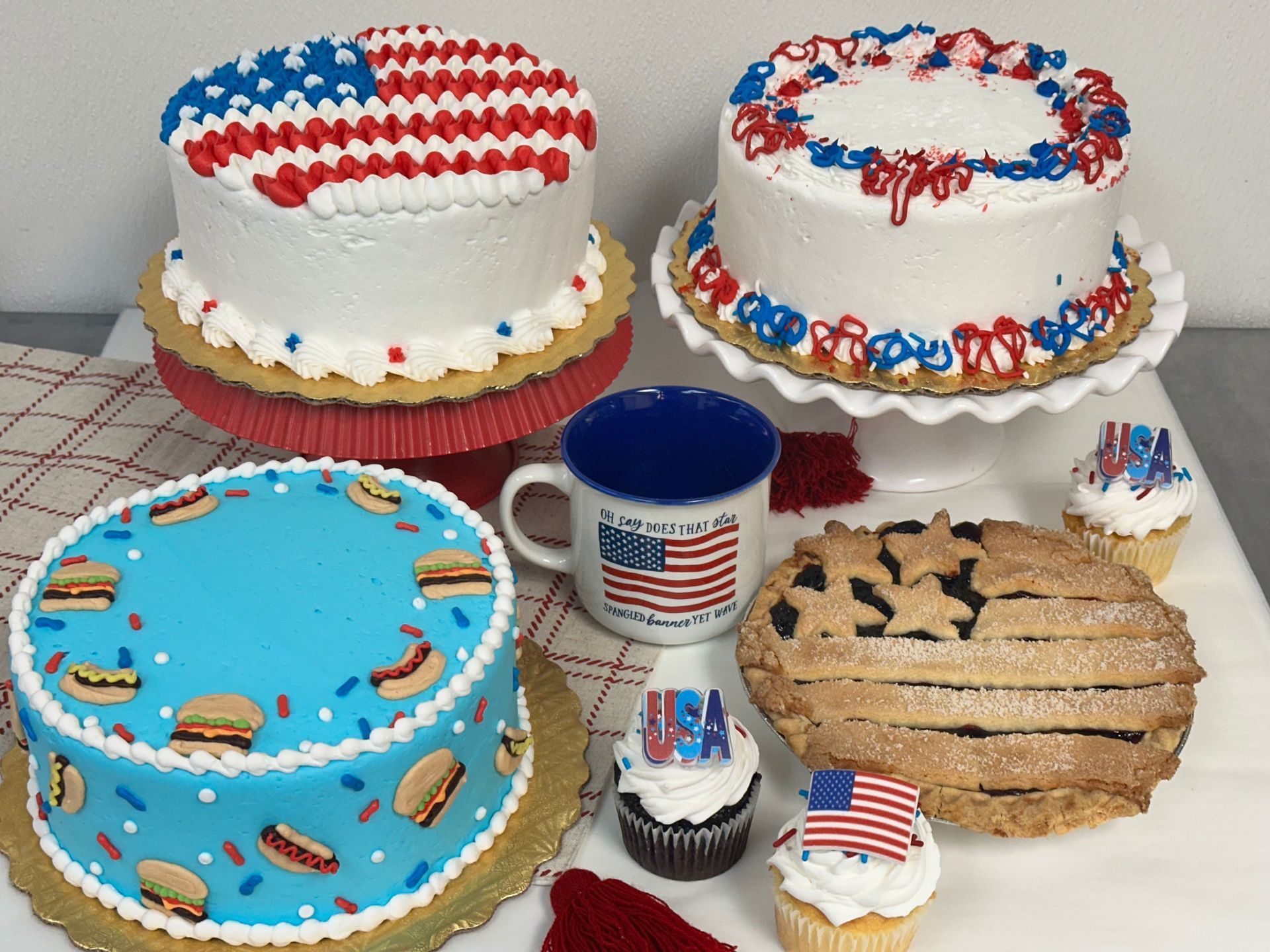 Patriotic-themed cakes, cupcakes, and treats decorated with red, white, and blue stars and flags