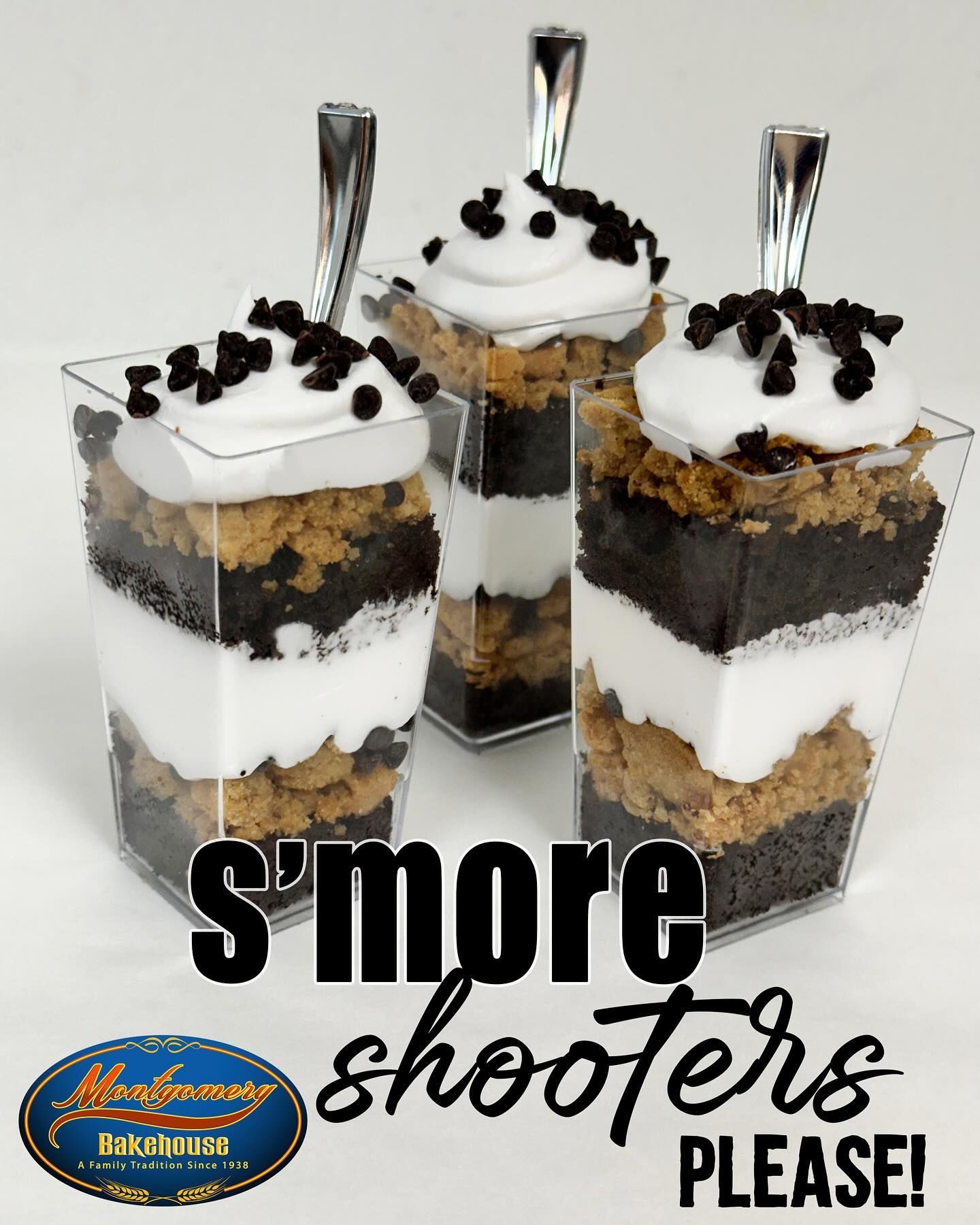 S'more shooters in clear cups with layers of chocolate, marshmallow, and cookie. Spoons and a logo are visible.