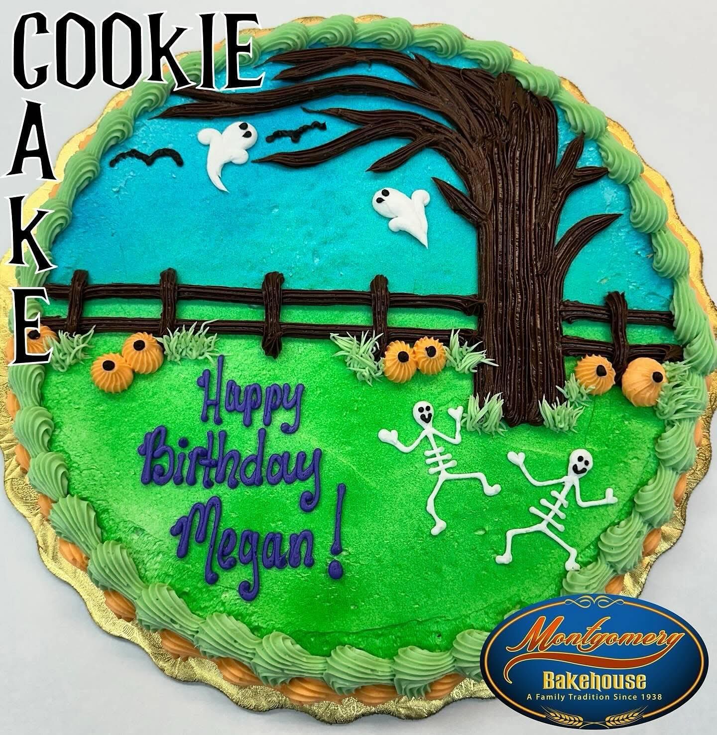 Halloween-themed birthday cookie cake with skeletons, ghosts, pumpkins, tree, fence, and 'Happy Birthday Megan!'
