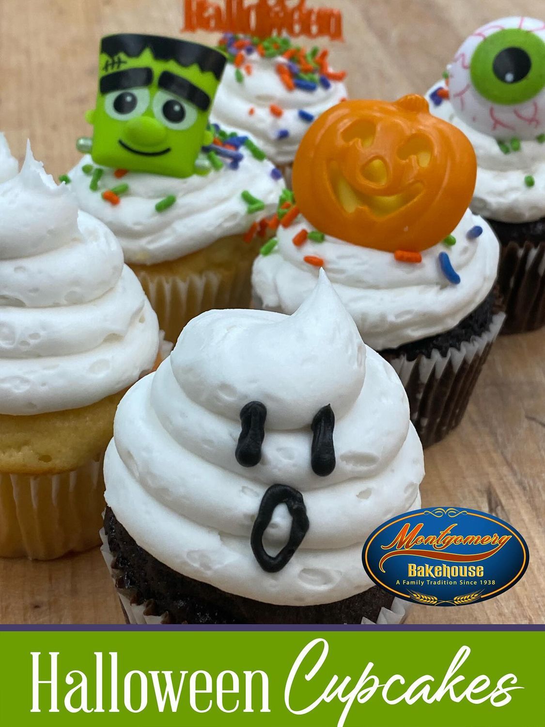 Halloween cupcakes with frosting and decorations, set on a wooden surface.