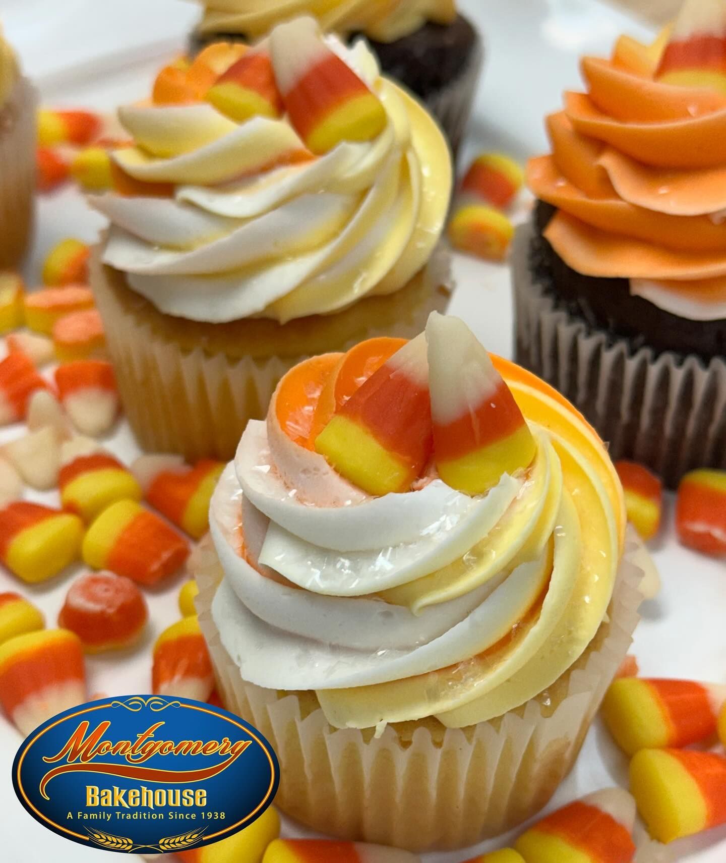 Cupcakes with frosting swirled in orange and yellow, topped with candy corn.