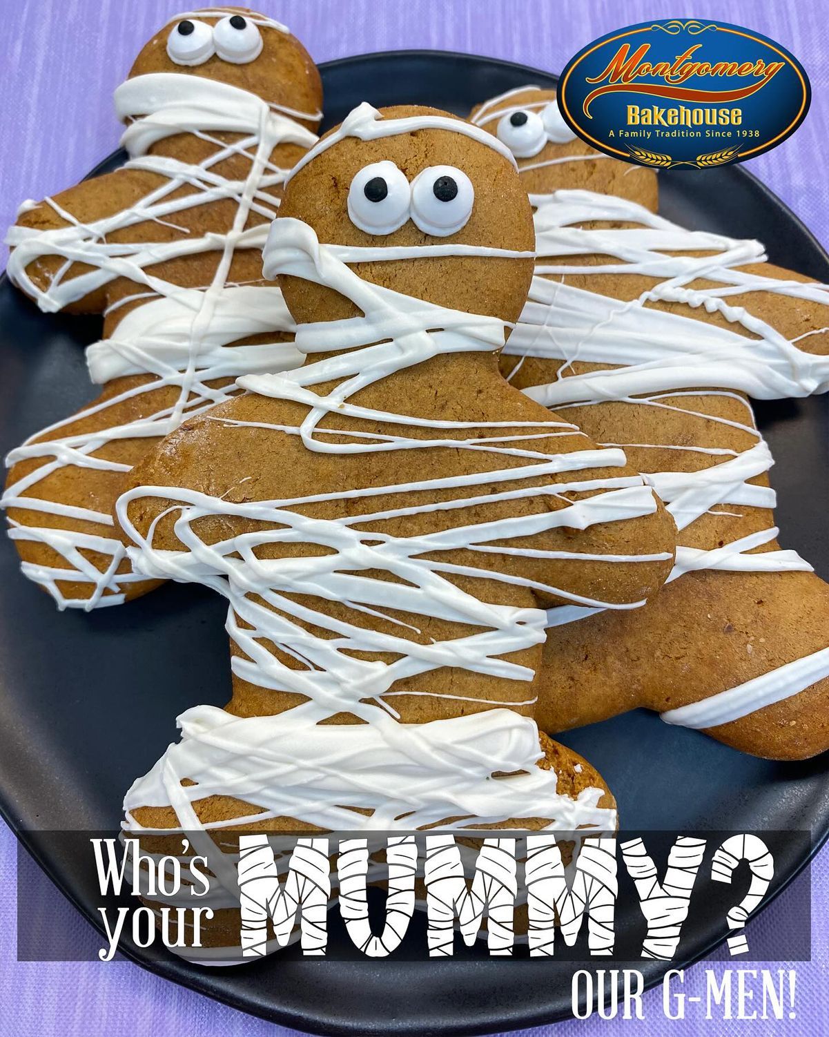 Gingerbread mummy cookies with white icing bandages on a black plate.