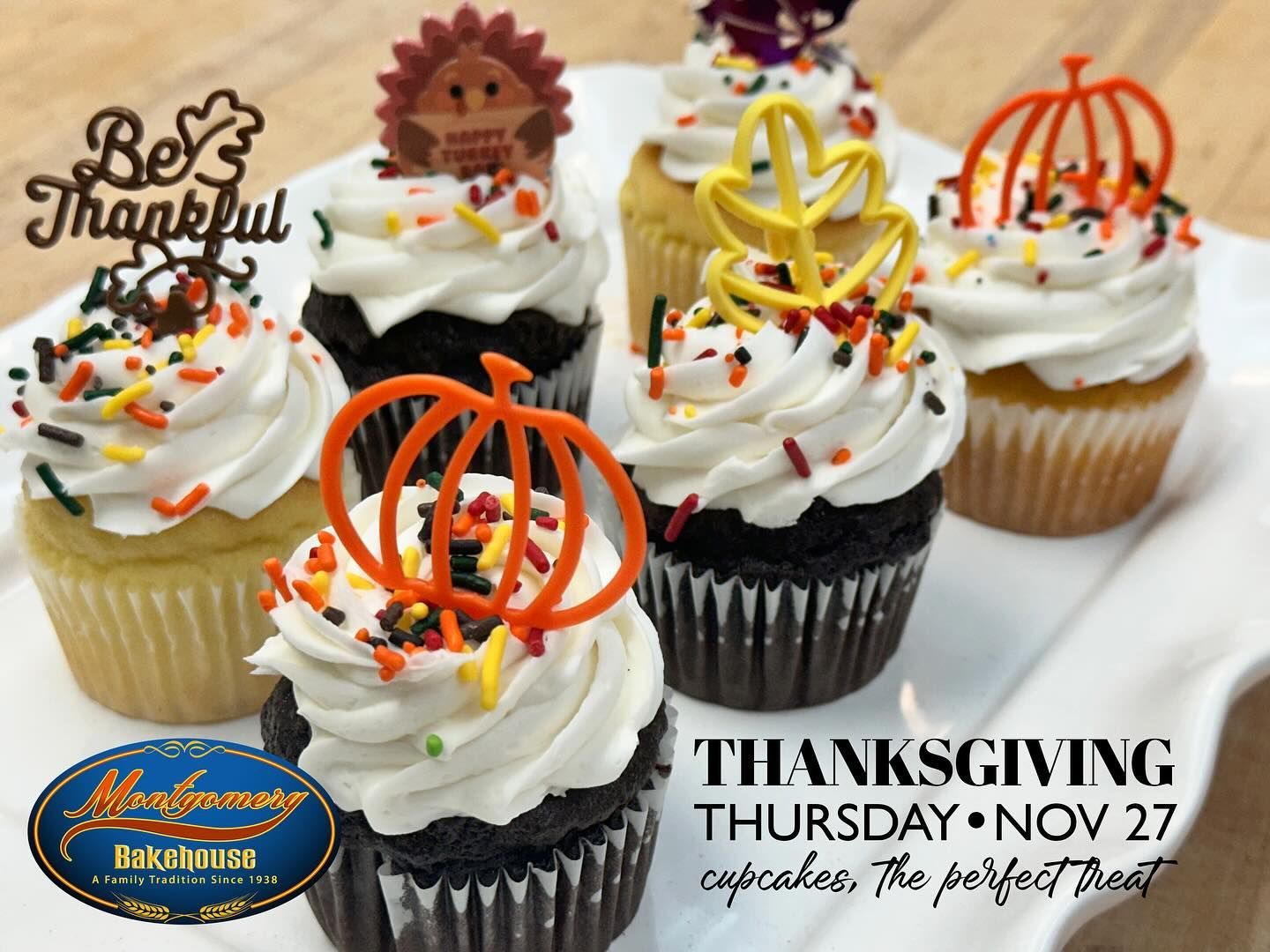 Thanksgiving cupcakes on a white platter, decorated with fall-themed toppers and sprinkles.