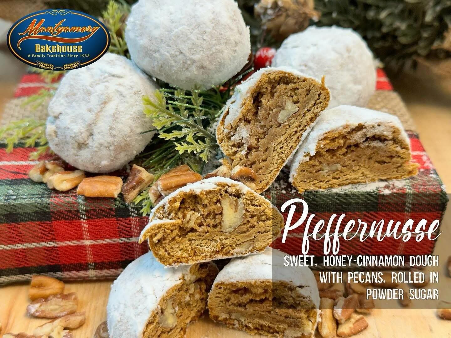 Pfeffernusse cookies dusted with powdered sugar, cut to show pecan filling, arranged on plaid fabric and greenery.