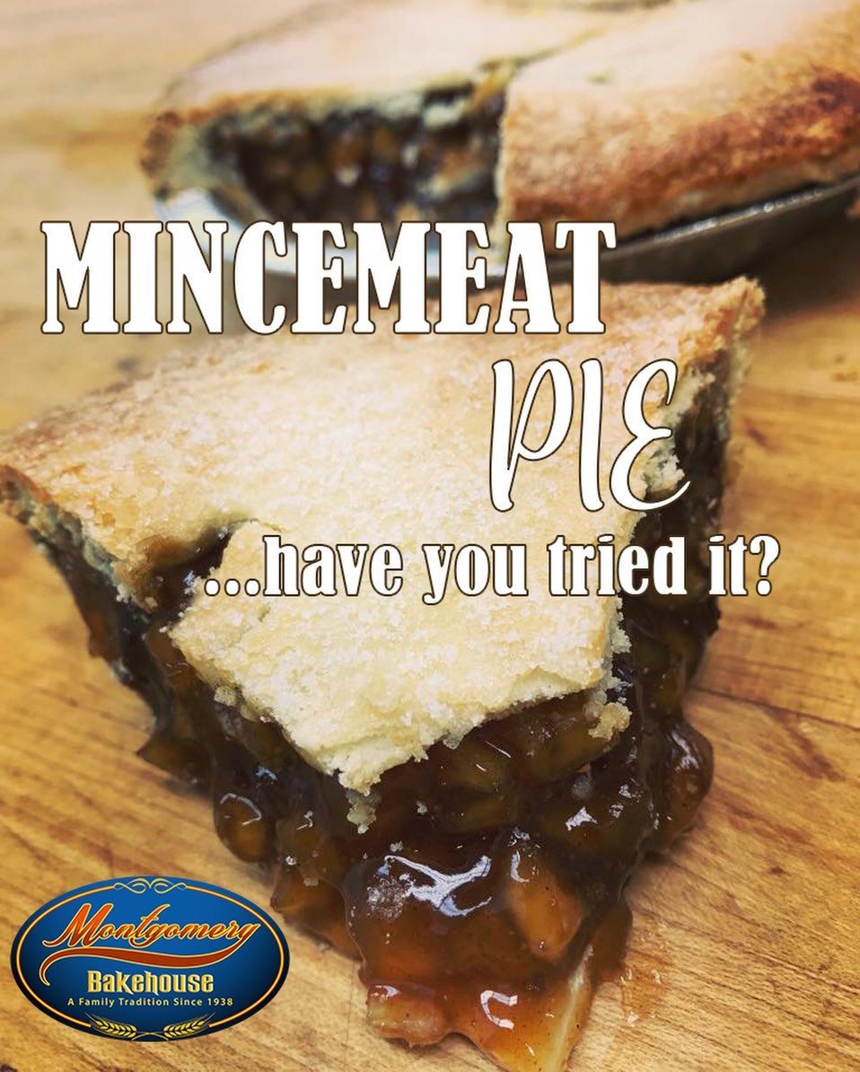 Mincemeat pie slice, golden crust, filling visible, on wooden surface with bakery logo.