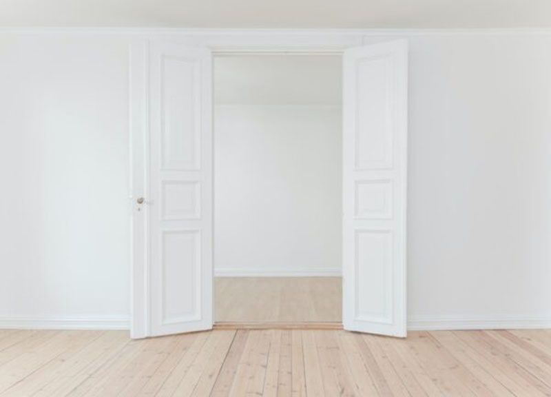 An empty room with two white doors open
