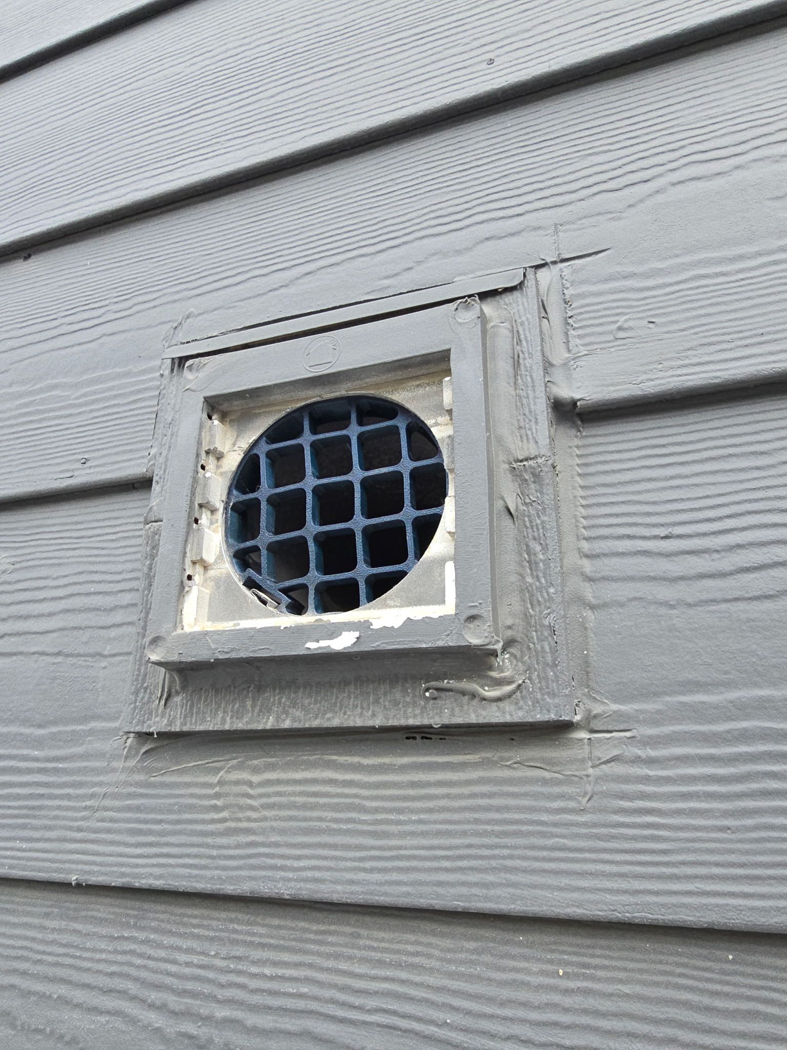 A close up of a vent on the side of a house
