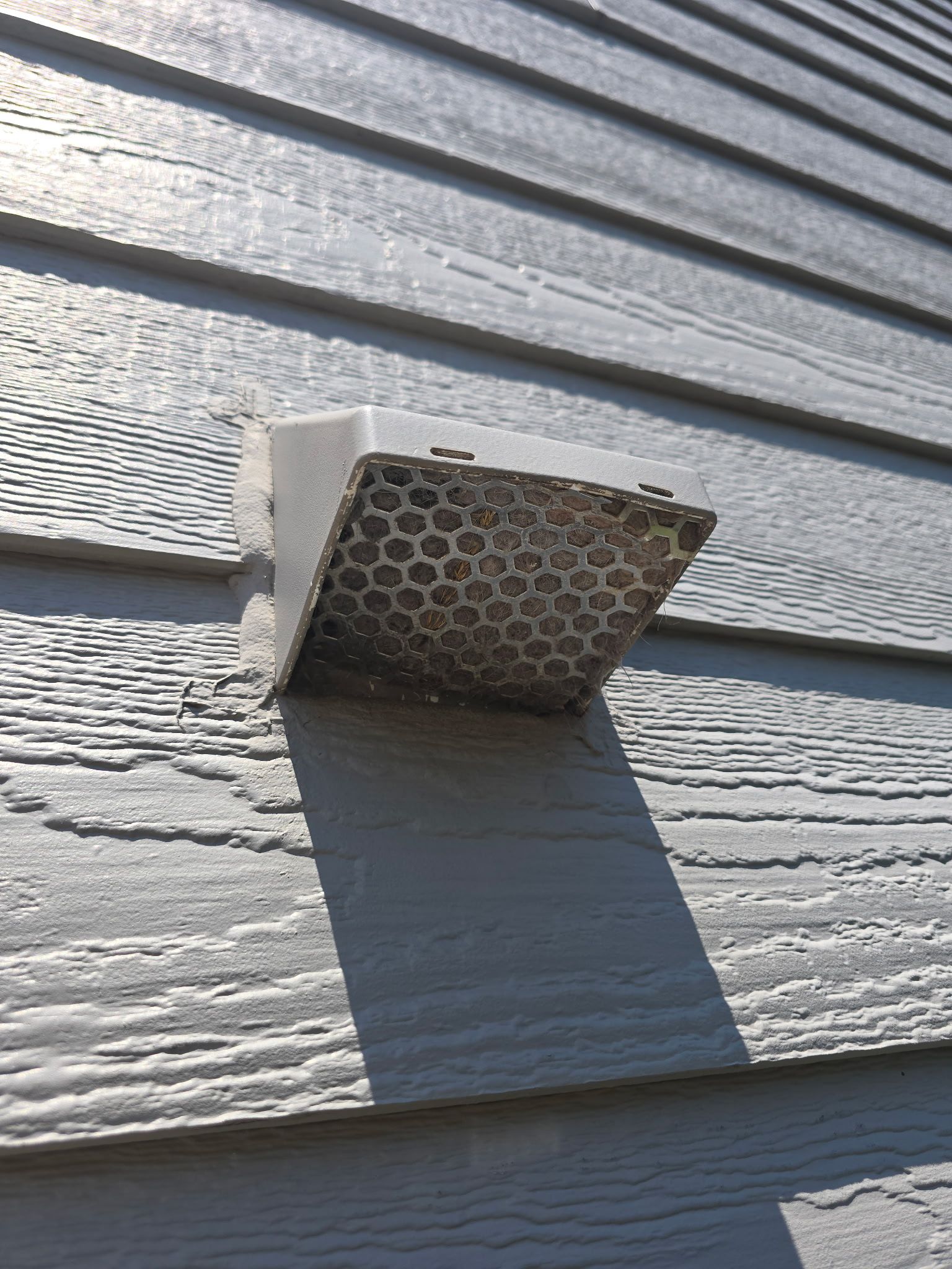 A close up of a vent on the side of a house
