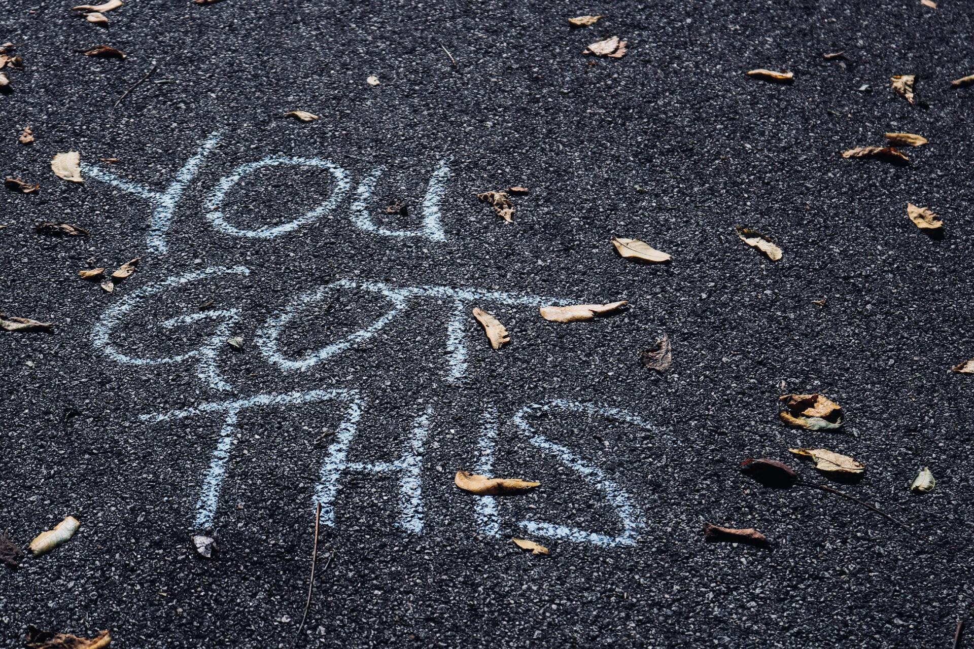 The words `` you got this '' are written in chalk on the ground.