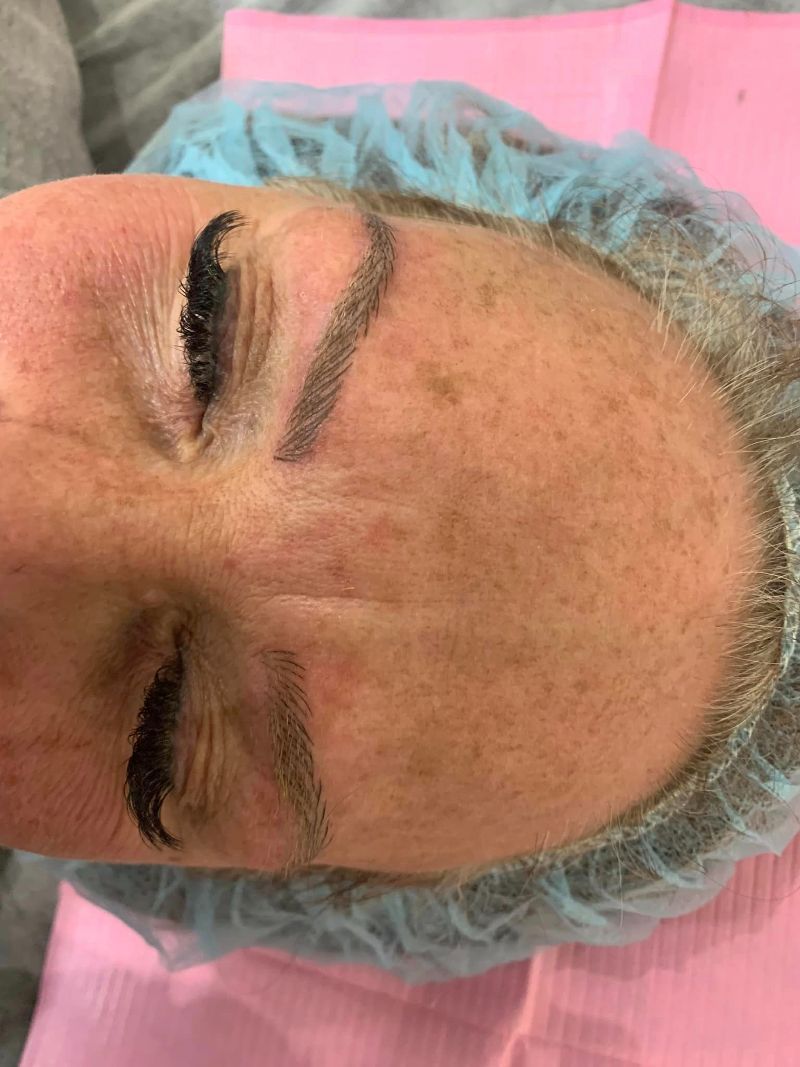 A woman is laying down with her eyes closed and wearing a blue plastic cap.