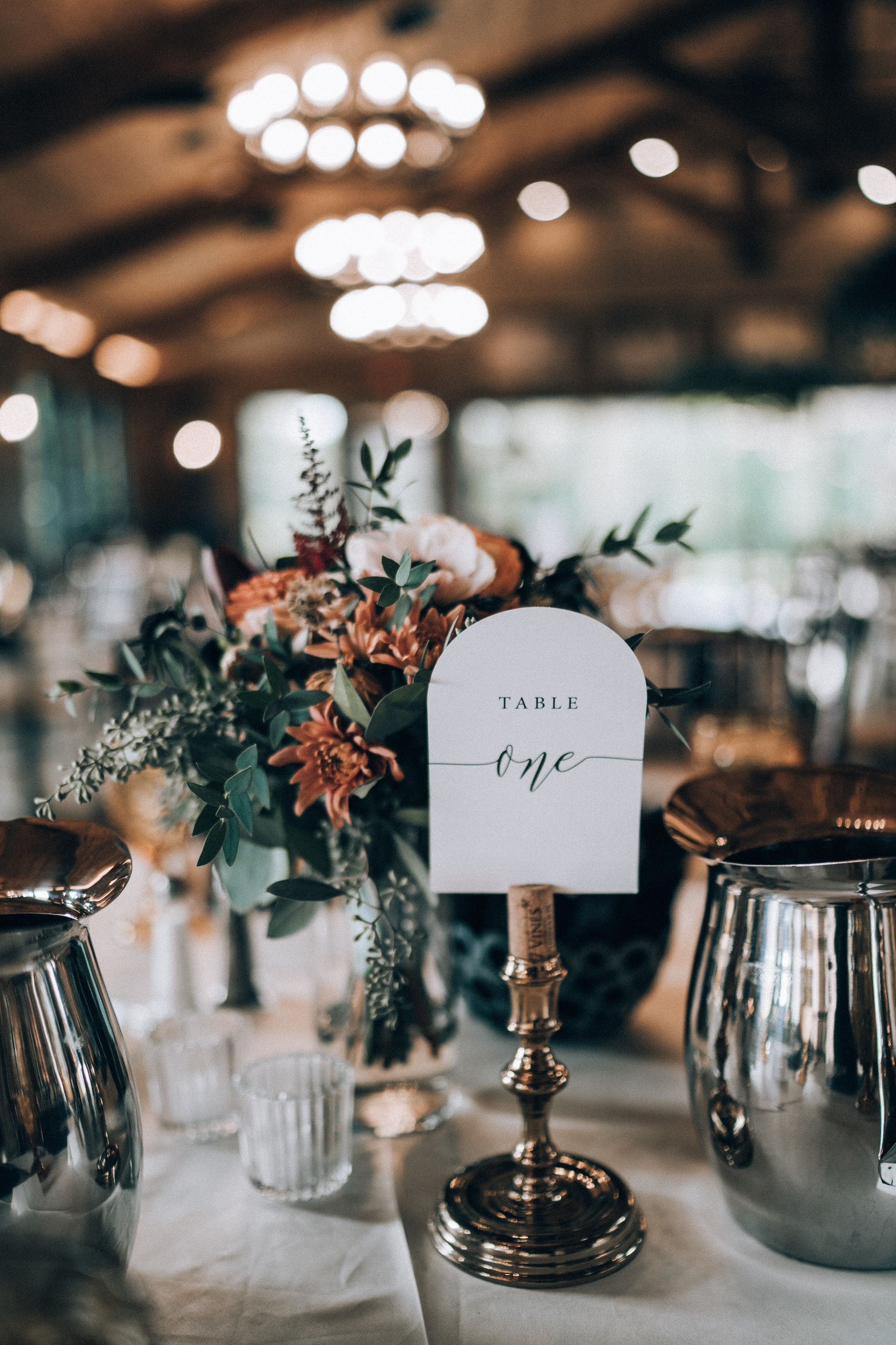 Wedding table setting with floral centerpiece and table number 