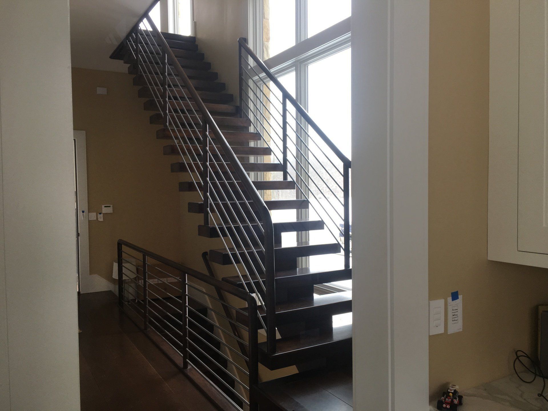 Interior staircase with black metal railings in a bright hallway