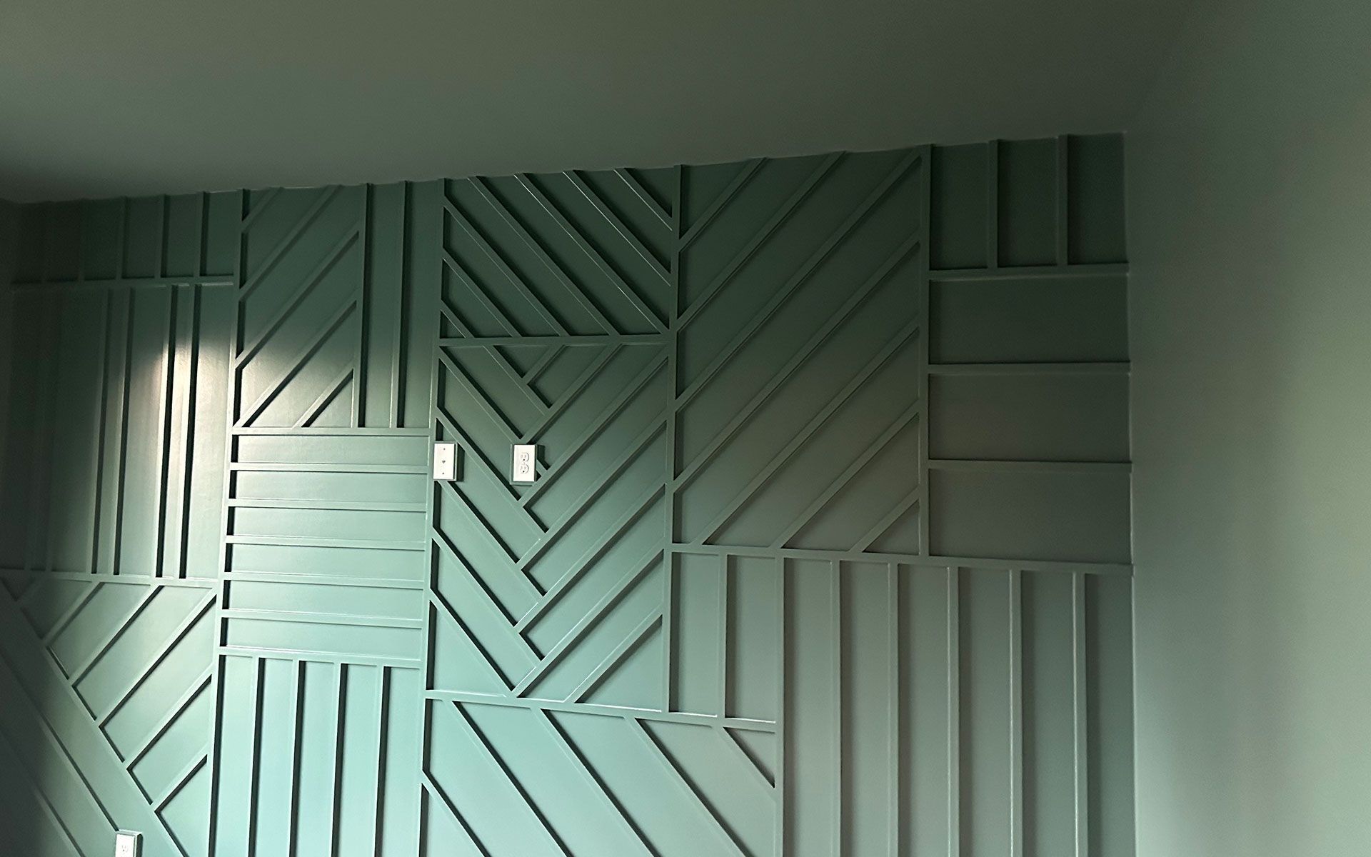 Modern geometric wood wall art in pale green and gray tones with diagonal and vertical slats