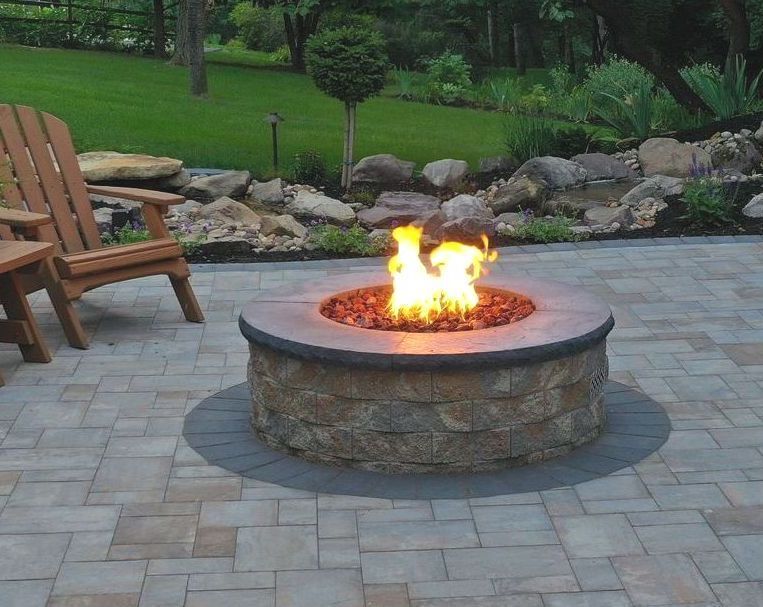 Burning round firepit on patio. Nicolock Serafina firepit kit for sale in Lebanon PA.