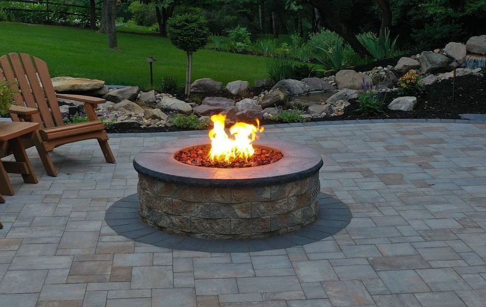 fire pit with flames on a stone patio