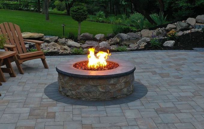 fire pit with flames on a stone patio