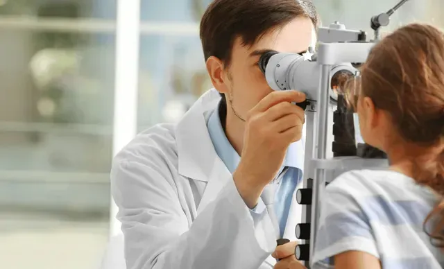A doctor is examining a little girl 's eye