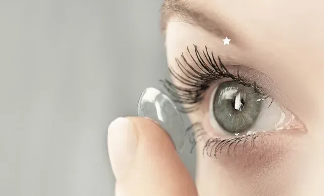 A woman is putting a contact lens in her eye