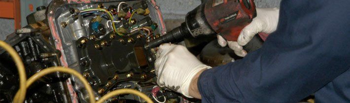 Workman tightening bolts on transmission