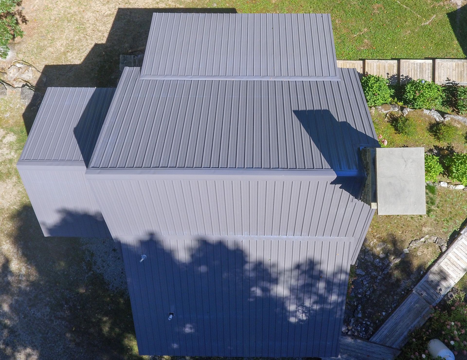 An aerial view of a house with a gray roof